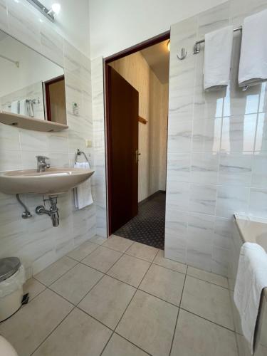 a bathroom with a sink and a toilet and a shower at Hotel Tabor Rooms in Vienna