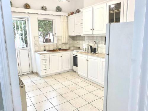 a kitchen with white cabinets and a tile floor at Renovated Condo in Athens in Athens