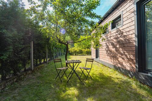 une table et des chaises dans l'herbe à côté d'un bâtiment dans l'établissement Rooms of Poland (500m od Suntago), à Krzyżówka