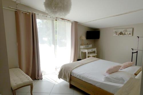 a bedroom with a bed and a large window at La ferme de Coron in Belley