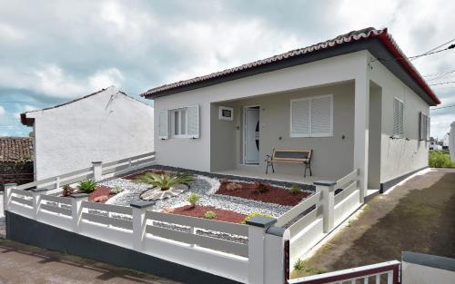 a white house with a garden in front of it at Resilience House in Feteira Grande