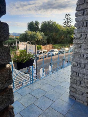 a blue fence with cars parked on a street at B&B La Pavoncella in San Teodoro