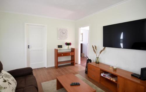 a living room with a couch and a flat screen tv at Resilience House in Feteira Grande