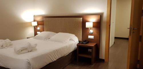 a bedroom with a large bed with white sheets and pillows at Balneario Elgorriaga in Elgorriaga
