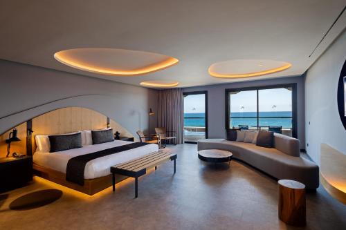 マスパロマスにあるHotel Faro, a Lopesan Collection Hotel - Adults Onlyのベッドとソファ付きのホテルルーム