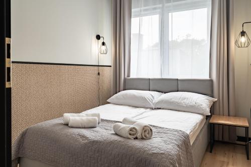a bedroom with a bed with towels on it at Apartamenty K2 Lubicka 7 in Toruń