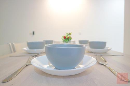 una mesa con tazones y cucharas y una taza en ella en Homely, Self Check-In, Wi-Fi, Guarded Community, en Seremban