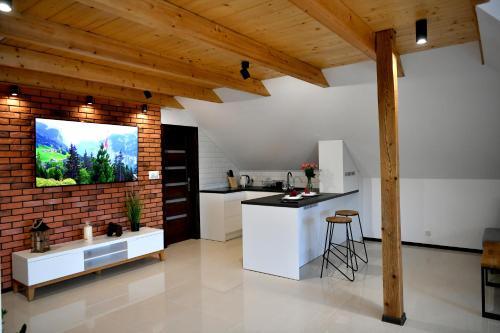 a kitchen with white cabinets and a brick wall at Apartament u Joli in Miejsce