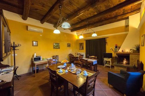 ein Wohnzimmer mit einem Tisch, Stühlen und einem Kamin in der Unterkunft Residenza Forte in Olevano sul Tusciano