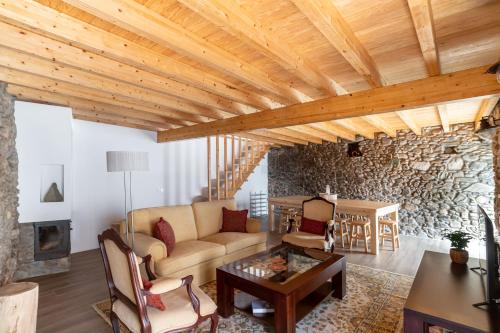 a living room with a couch and a stone wall at Beautiful House in Miranda do Corvo