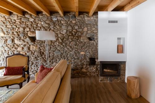 a living room with a couch and a stone wall at Beautiful House in Miranda do Corvo