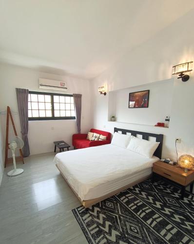 a bedroom with a large bed and a red couch at 小時公館城西 in Yuli