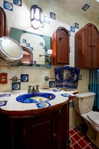 a bathroom with a sink and a toilet and a mirror at Casa Colonial Taxco Centro in Taxco de Alarcón