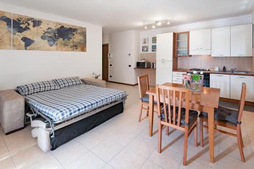 een slaapkamer met een bed en een tafel en een keuken bij View House - Lake Como in Pescate