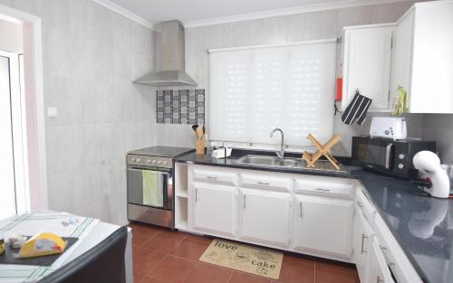 a kitchen with a sink and a stove at Resilience House in Feteira Grande