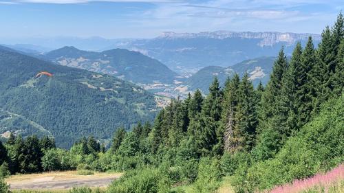 a person flying a kite in a mountain valley at Ski-to-door apartment au Collet d'Allevard in Allevard