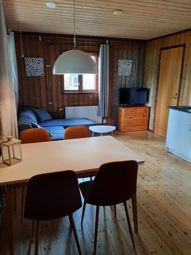 un soggiorno con tavolo, sedie e divano di Skabram Camping & Stugby a Jokkmokk