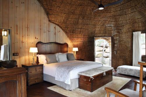 um quarto com uma cama e uma parede de madeira em Shambala Private Game Reserve em Vaalwater