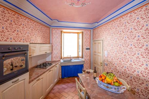a kitchen with a table with a bowl of fruit on it at IBibiena -SUITE CASA FIORITA in Bibbiena