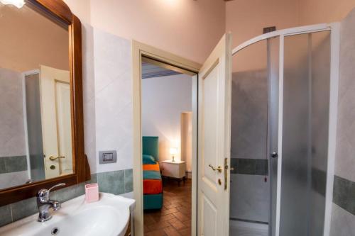 a bathroom with a sink and a shower and a mirror at IBibiena -SUITE CASA FIORITA in Bibbiena