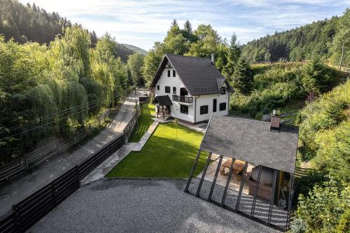 an aerial view of a white house in the woods at Villa Trésor Voronet in Gura Humorului