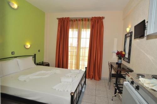 a bedroom with a bed and a desk and a window at Evelin hotel in Pythagoreio