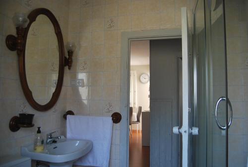 ein Bad mit einem Waschbecken und einem Spiegel in der Unterkunft Apartamento A Cascada in Cee