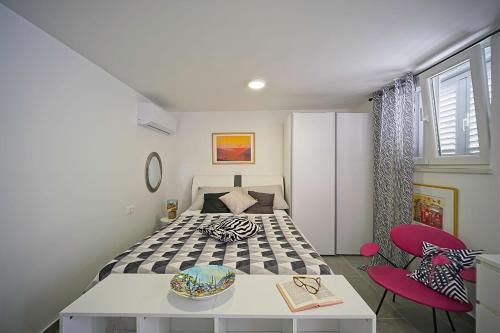 1 dormitorio con 1 cama, mesa y sillas en Apartments Lux, en Makarska