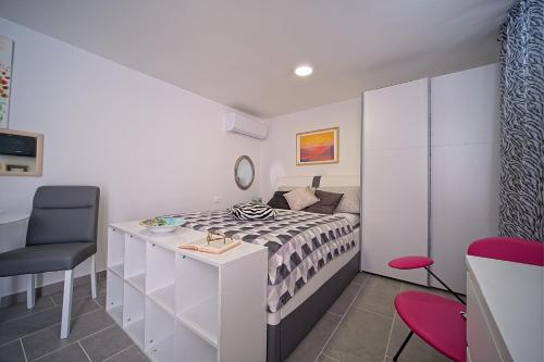 a bedroom with a bed and a desk and a chair at Apartments Lux in Makarska