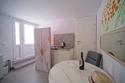 a white room with a table and a kitchen at Apartments Lux in Makarska