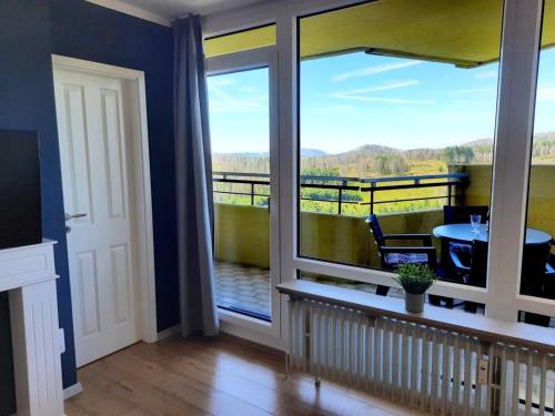 een kamer met een balkon met een tafel en uitzicht bij Apartment 560 in Hohegeiß