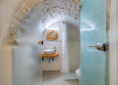 a bathroom with a white toilet and a sink at D House in Ceglie Messapica