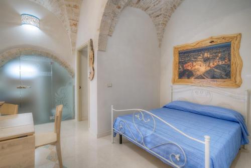a bedroom with a bed with a painting on the wall at D House in Ceglie Messapica