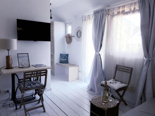 a white living room with a desk and a window at Casa Babica Guesthouse in Costinesti