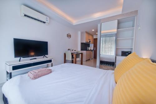 a bedroom with a large white bed and a television at AMAZING VIEW Studio in Laguna Beach Resort 2. in Jomtien Beach