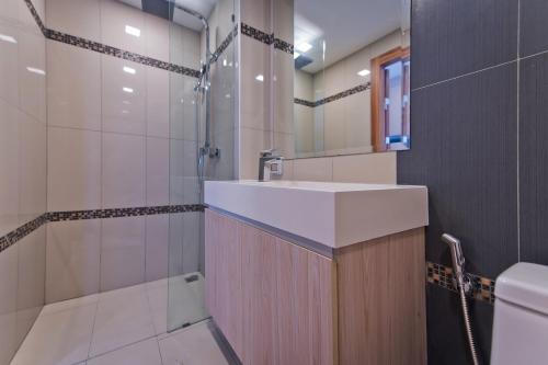 y baño con lavabo y ducha. en AMAZING VIEW Studio in Laguna Beach Resort 2., en Jomtien Beach