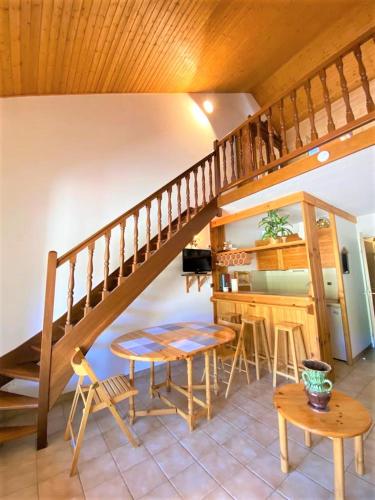 un salon avec une table et un escalier dans l'établissement Résidence Les Arcades 2 pièces 8 personnes, à Saint-Étienne-en-Dévoluy