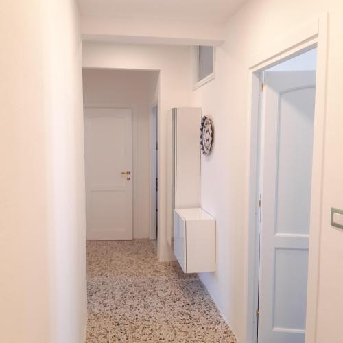 a hallway with a white door and a white refrigerator at Il veliero in Alghero