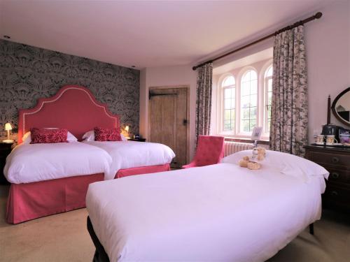 a bedroom with two beds and a teddy bear on top of them at Leeds Castle Maiden's Tower in Maidstone