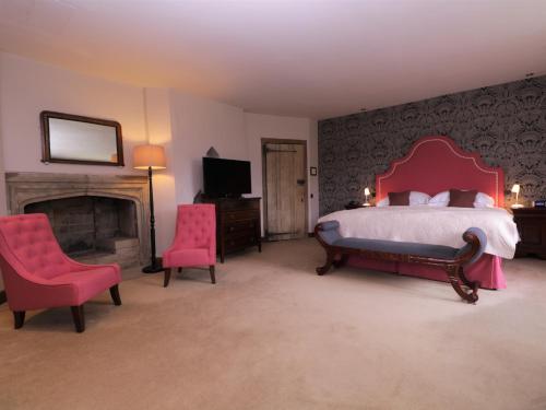 a bedroom with a large bed and a fireplace at Leeds Castle Maiden's Tower in Maidstone