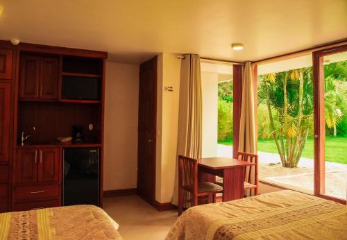 1 dormitorio con cama, escritorio y ventana en Bamboo Village Place, en Tumbaco