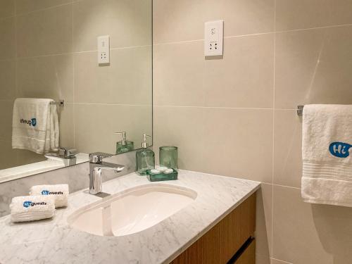 ein Bad mit einem Waschbecken und einem Spiegel in der Unterkunft HiGuests - Stylish Apt With Stunning Beach Views and Pools in Dubai