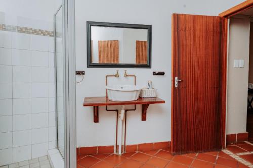 baño con lavabo y espejo en la pared en Riverbank Lodge, en Upington