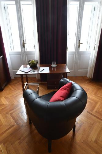 a black leather couch sitting in a living room with a table at B&B Al Giardino Leonor in Trieste