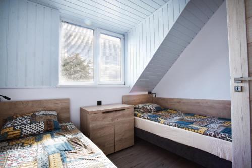 two beds in a room with two windows at Wiking in Kretowiny