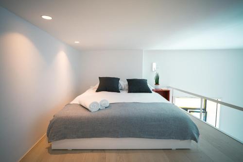 a bedroom with a bed with two pillows on it at PORTARIA HOUSING in Aveiro