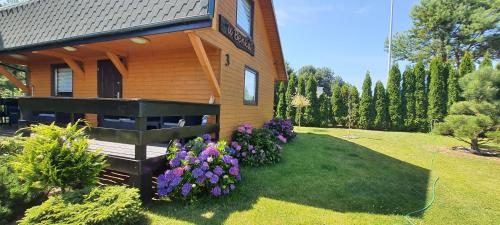 una casa con flores púrpuras en el patio en U Benka en Wisełka