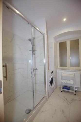 a bathroom with a shower and a washing machine at Villa Fani in Rijeka