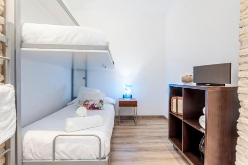 CASA ESPECTACULAR DE DISEÑO CON JARDIN INTERIOR في فالنسيا: غرفة نوم صغيرة مع سرير بطابقين وتلفزيون