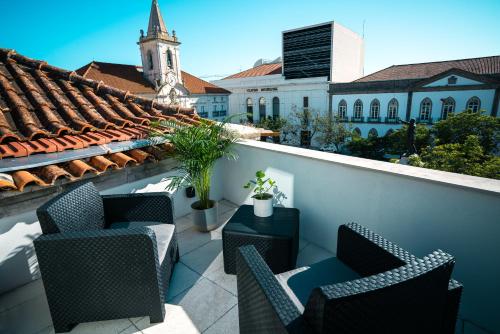 a rooftop patio with chairs and a building at PORTARIA HOUSING in Aveiro